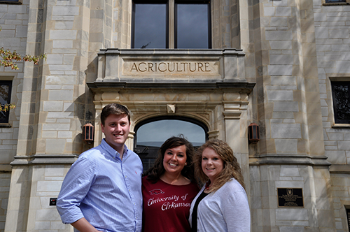 Three AECT Graduate students standing in front of the AGRI building